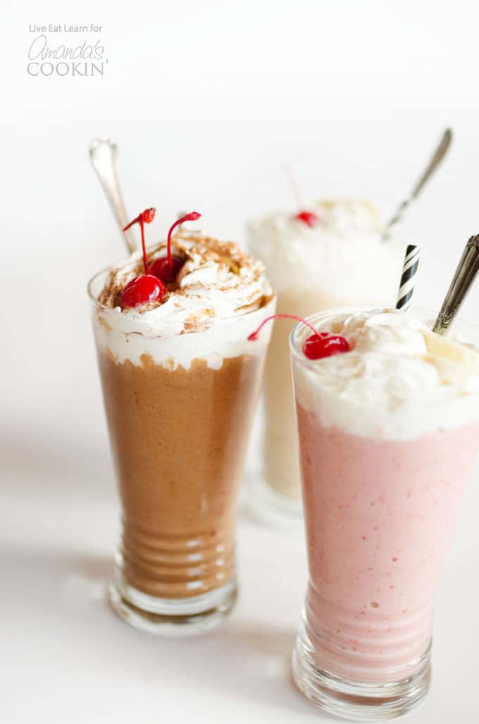 chocolate shake with a cherry, strawberry shake in foreground