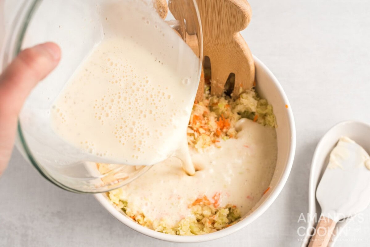 pouring dressing into cabbage slaw