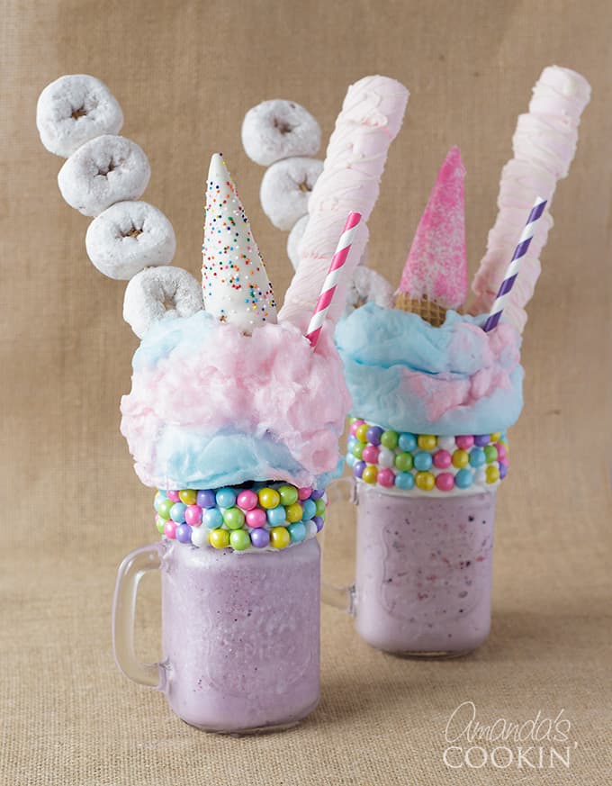 two purple milkshakes with donuts and marshmallows