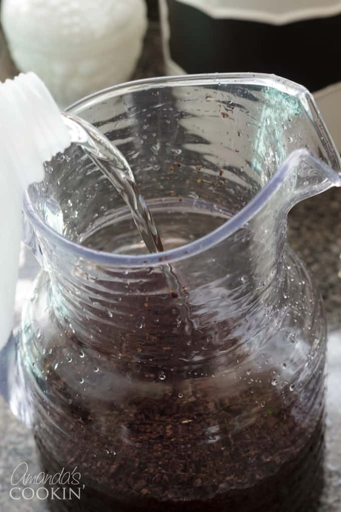 Place the ground coffee into a 2-quart pitcher and fill the pitcher with fresh water. Stir the mixture to make sure all the beans are wet.