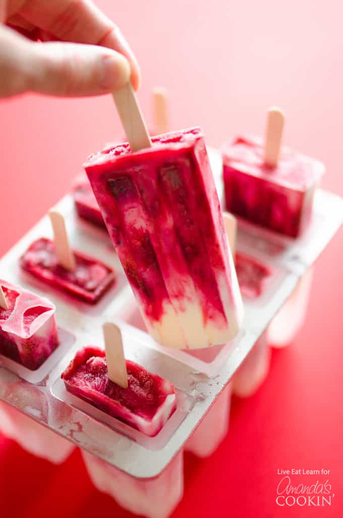 cherry yogurt popsicles being removed from molds