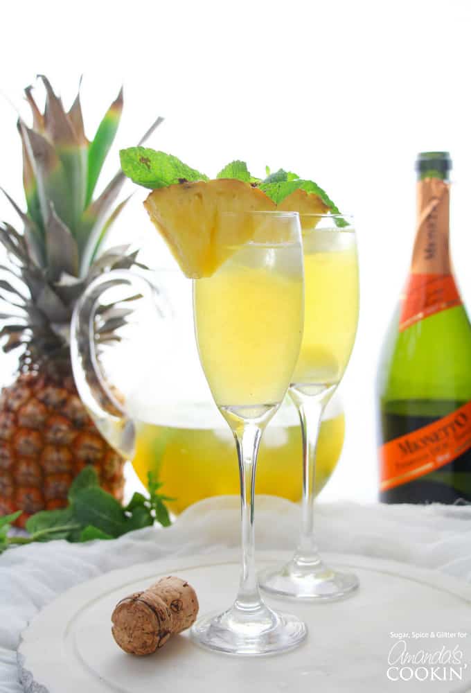 flutes with pineapple prosecco punch and pineapple garnish