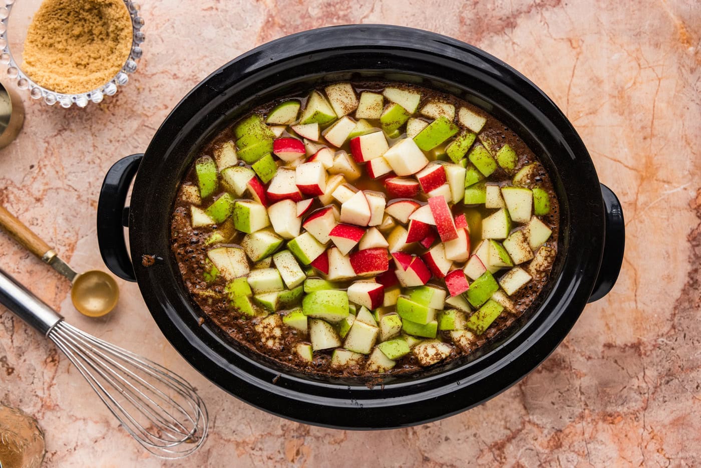 Crockpot with chopped apples floating on top