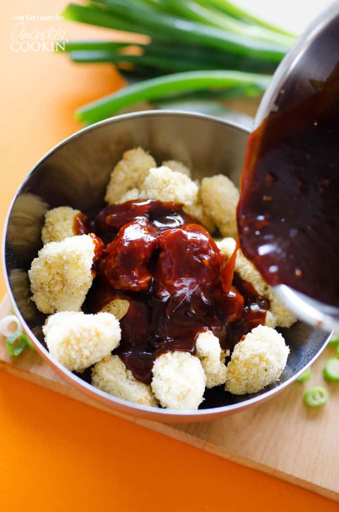 Mixing sauce with breaded cauliflower