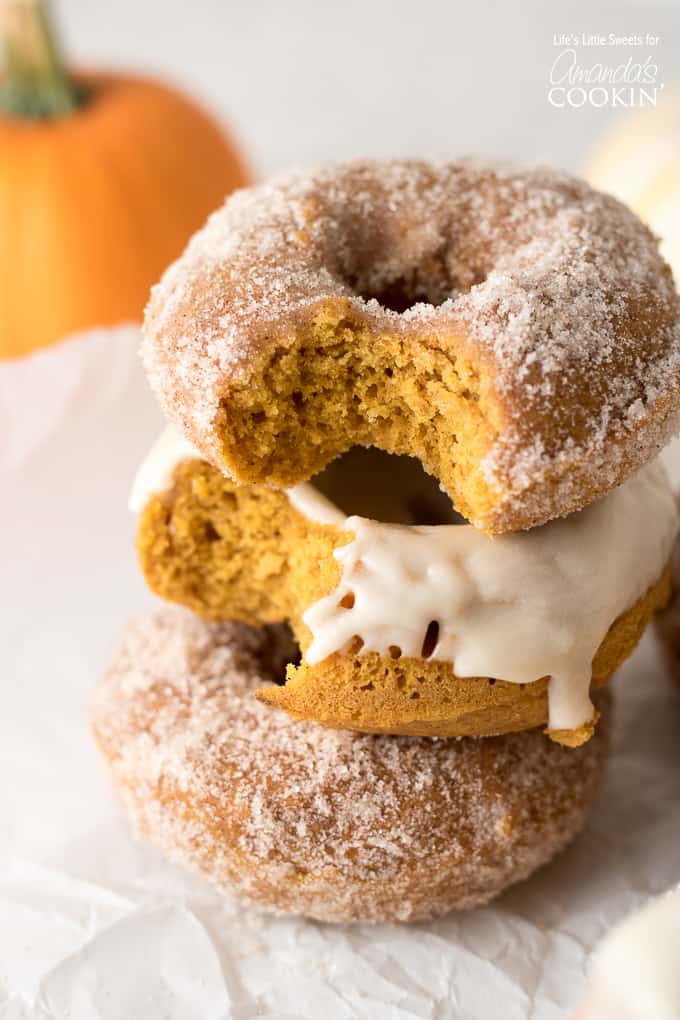stacked pumpkin donuts with bites taken out