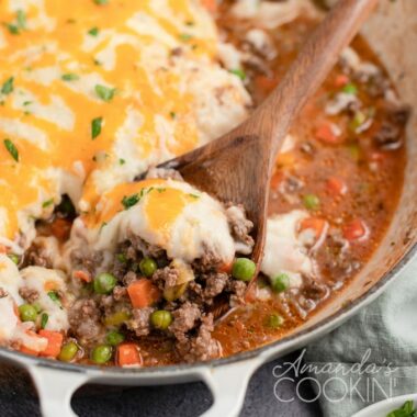 close up shepherds pie in a wooden spoon