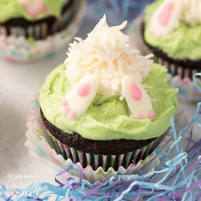 A close up of a decorated bunny butt cupcake on a table