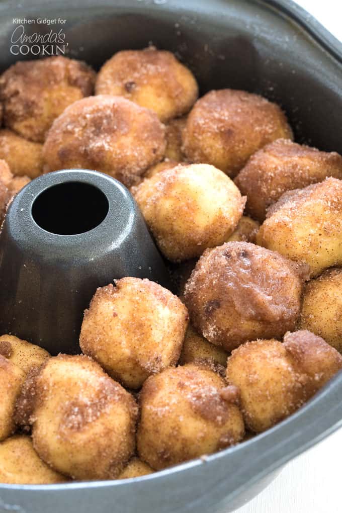 dough balls coated in cinnamon sugar in bundt pan