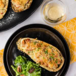 overhead photo of stuffed baked eggplant parmesan on black plates