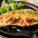 stuffed baked eggplant parmesan on a black plate