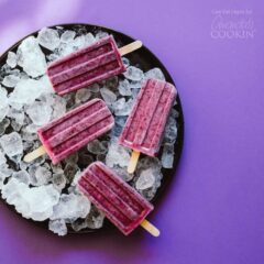 overhead shot of blueberry popsicles on a plate of ice