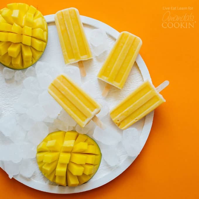 Mango Yogurt popsicles on a plate of ice