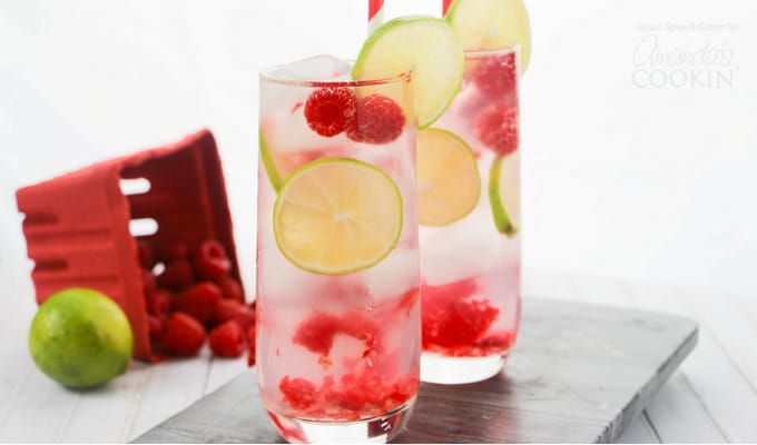 Raspberry Gin Rickey in glasses with lime and raspberries