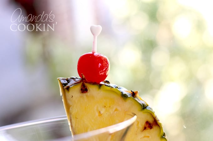 pineapple wedge and maraschino cherry on side of glass