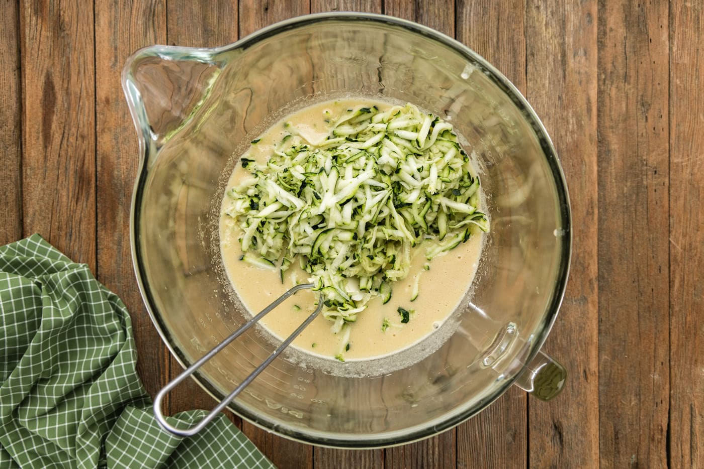 wet ingredients and shredded zucchini in a bowl
