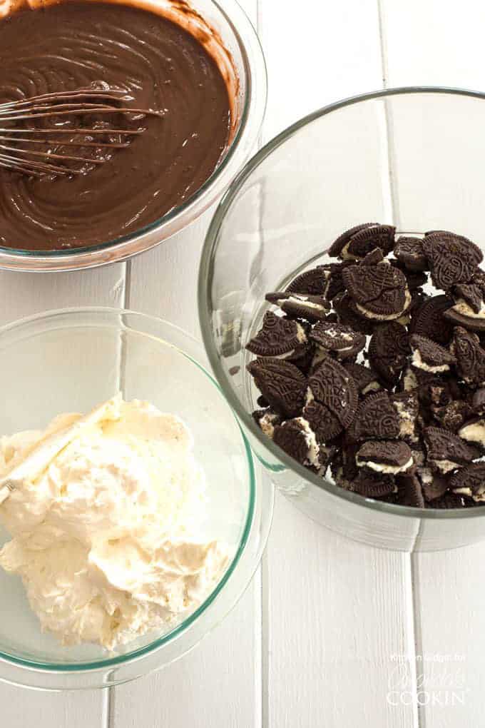 Oreos, chocolate pudding, and whipped topping in bowls