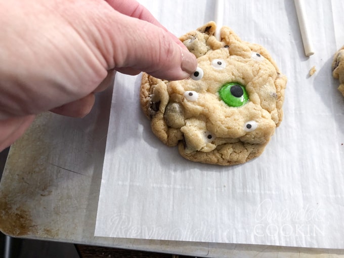 adding candy eyeballs to baked cookies