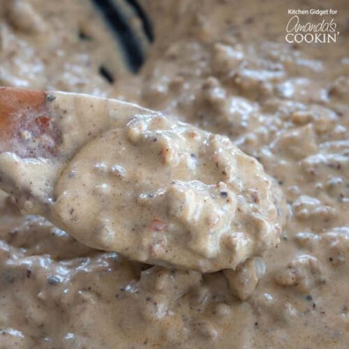 close up of sausage gravy in pan with wooden spoon