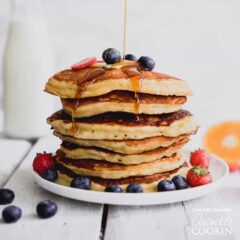 plate of stacked pancakes with blueberries