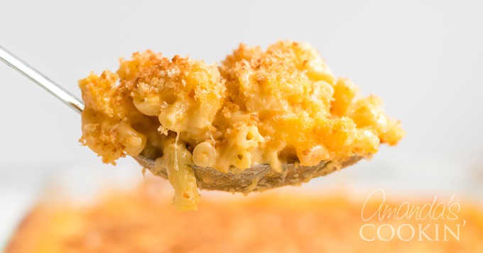 serving spoon with baked mac and cheese with breadcrumbs