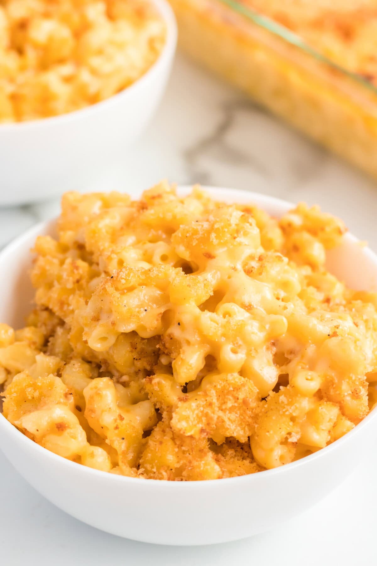 Bowl of Baked Macaroni and Cheese with another bowl behind it