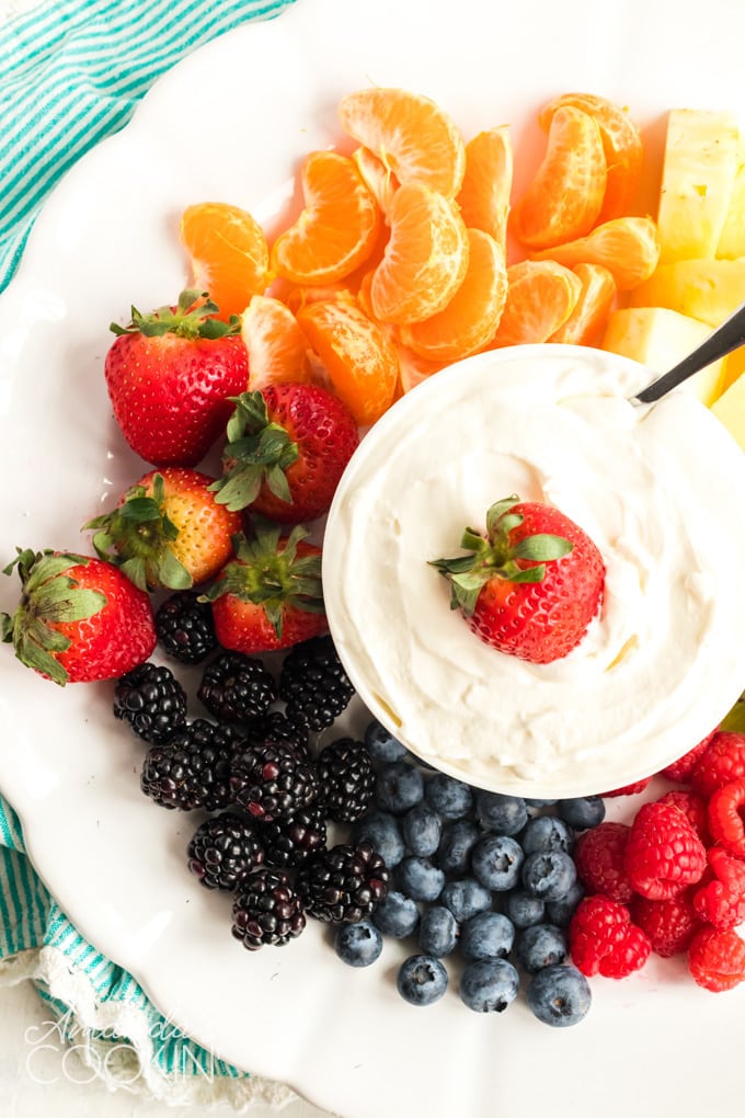 WHITE PLATE FULL OF FRUIT WITH FRUIT DIP IN THE MIDDLE