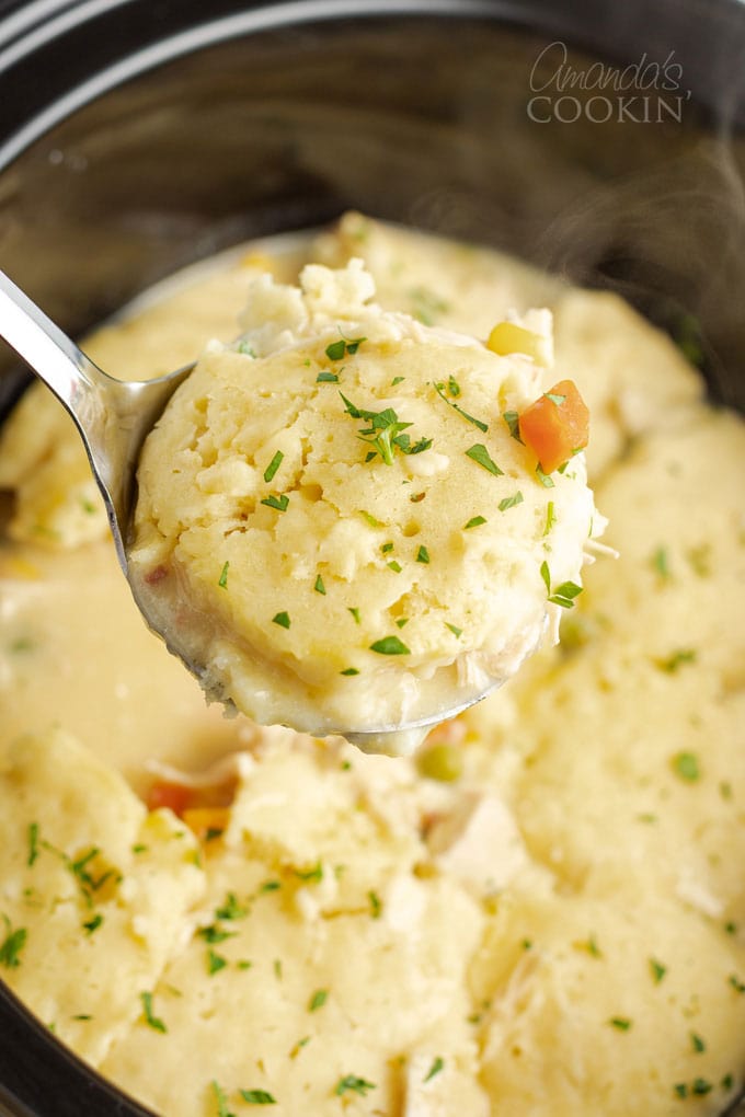 spooning chicken and dumplings from the slow cooker