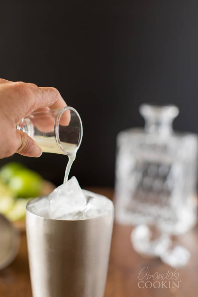 pouring lime juice into cocktail shaker