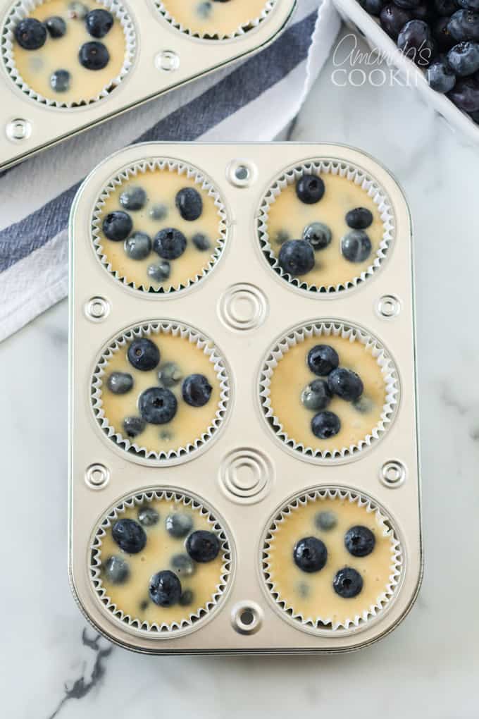 muffin pan with blueberry muffin batter