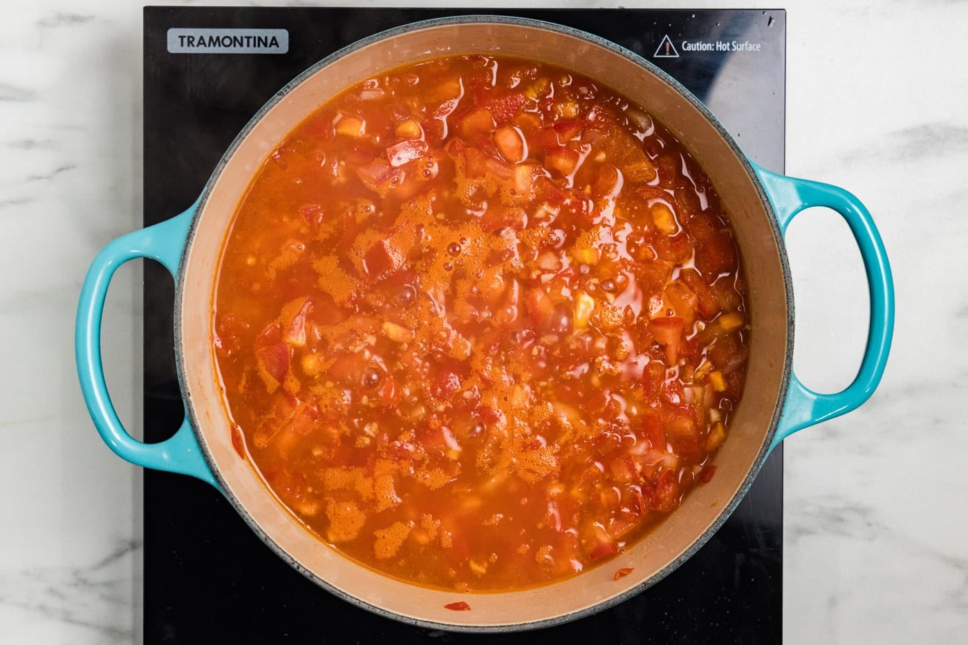 fresh tomatoes bubbling in pot with broth