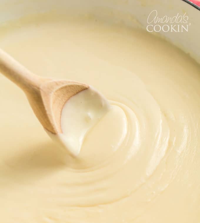 wooden spoon stirring cheese sauce