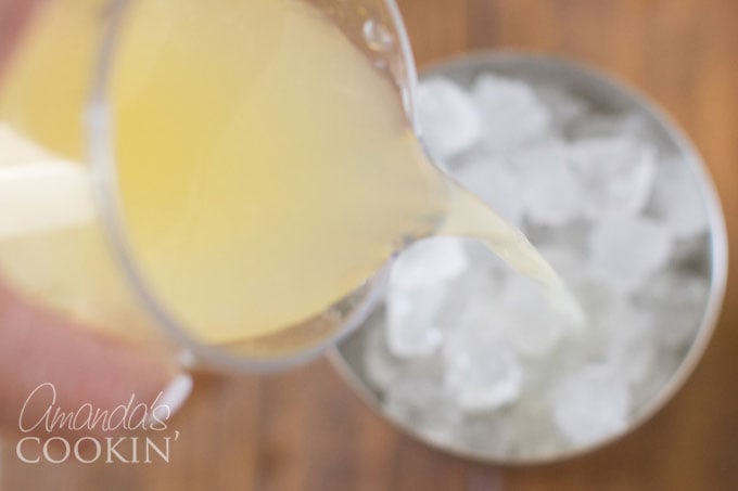 adding lemon juice to cocktail shaker