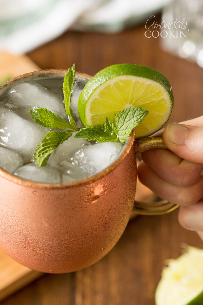 hand holding a copper mug of moscow mule