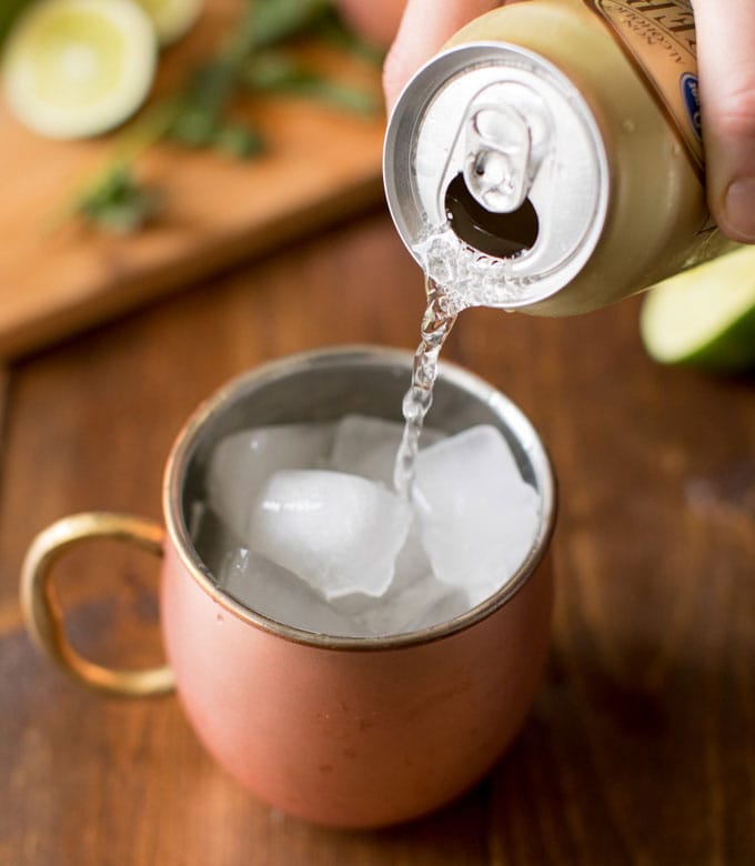 pouring ginger beer into copper mug