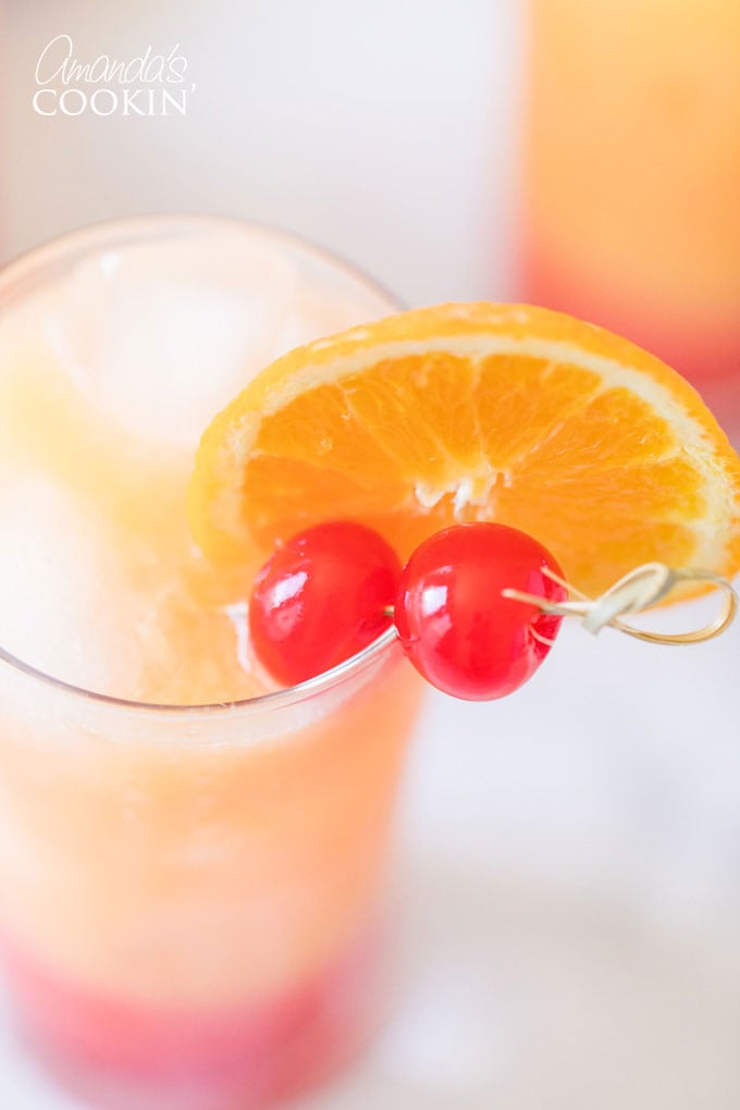 close up of glass with orange and cherry garnishes