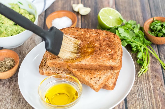 brushing toast with olive oil