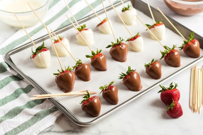 dipped strawberries lined up on a pan