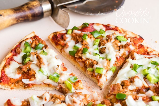 pizza sliced with a pizza wheel in background