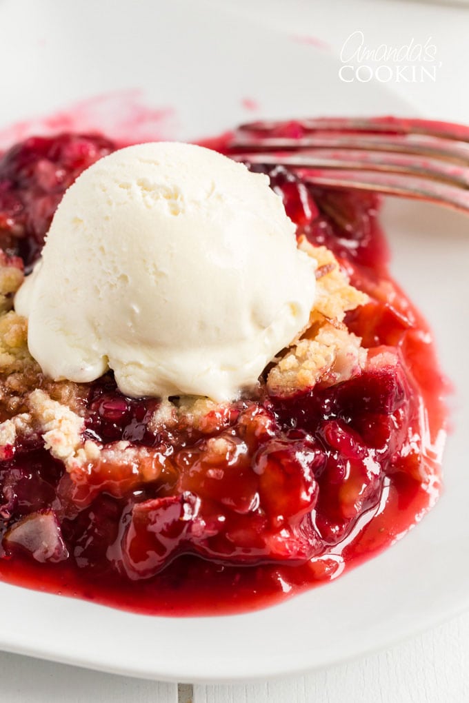 close up of rhubarb crumble with vanilla ice cream on a plate