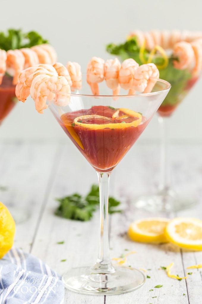 martini glass with cocktail sauce and shrimp on rim