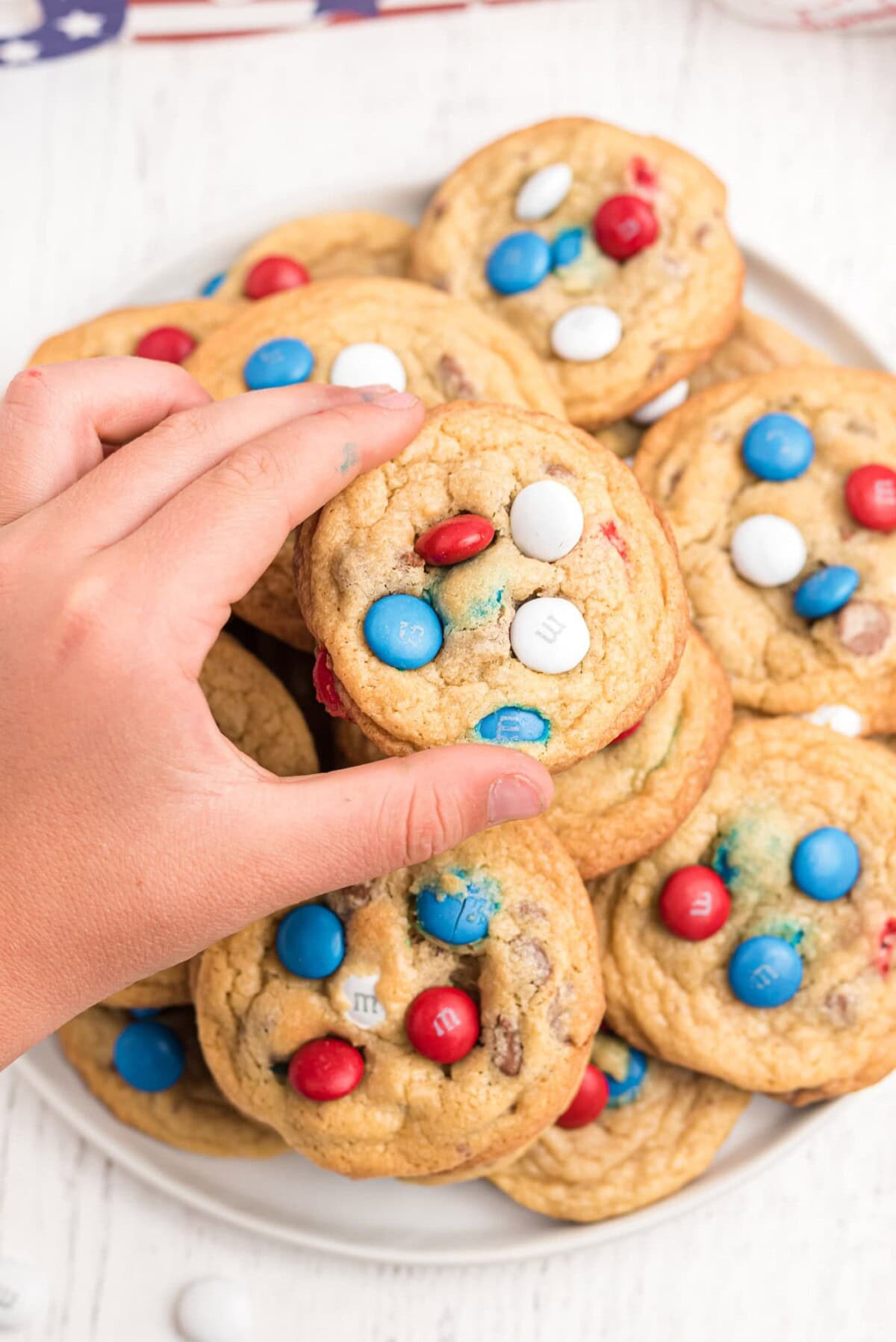 child taking a patriotic cookie from a plate