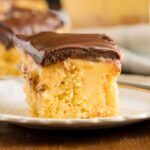 slice of boston cream poke cake on a white plate