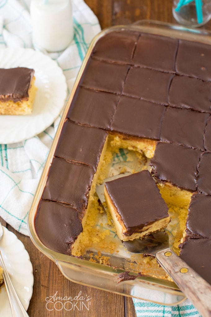 overhead photo of chocolate cake in a glass pan with a slice being lifted out