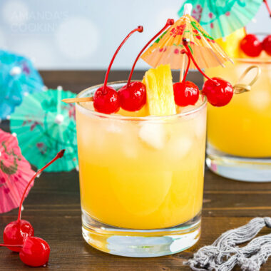 mai tai in a rock glass garnished with cherries and pineapple