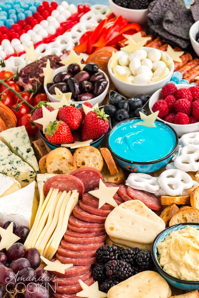 close up of appetizer cheese board, shows veggies and fruits and dip