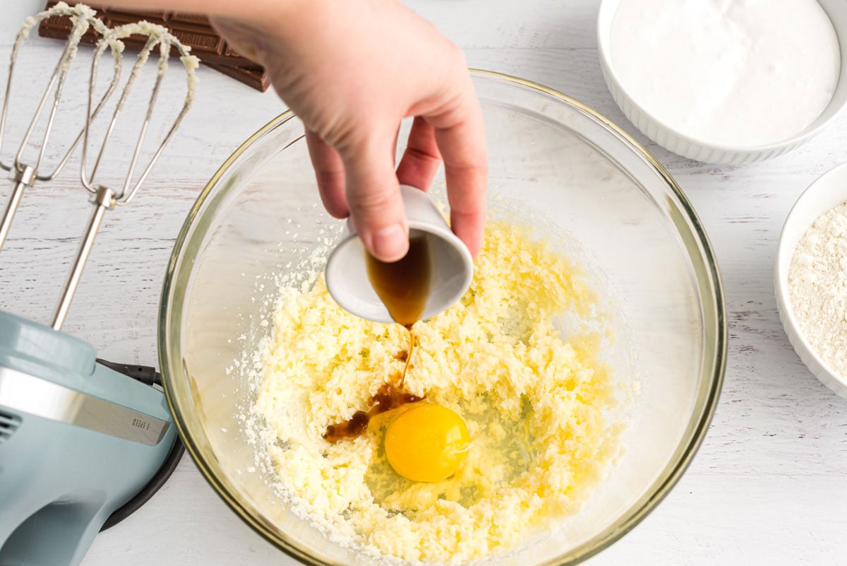 adding vanilla to eggs in bowl