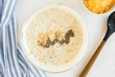 bowl of corn dip with seasonings added to the top of it