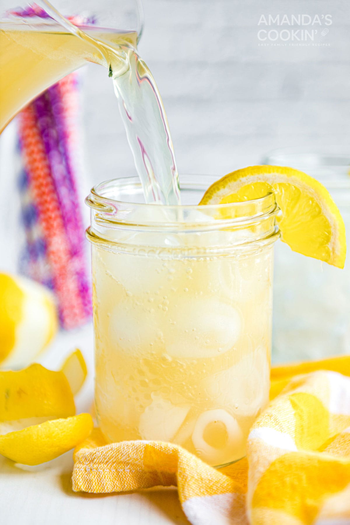 pouring Lynchburg lemonade into a mason jar glass form a pitcher