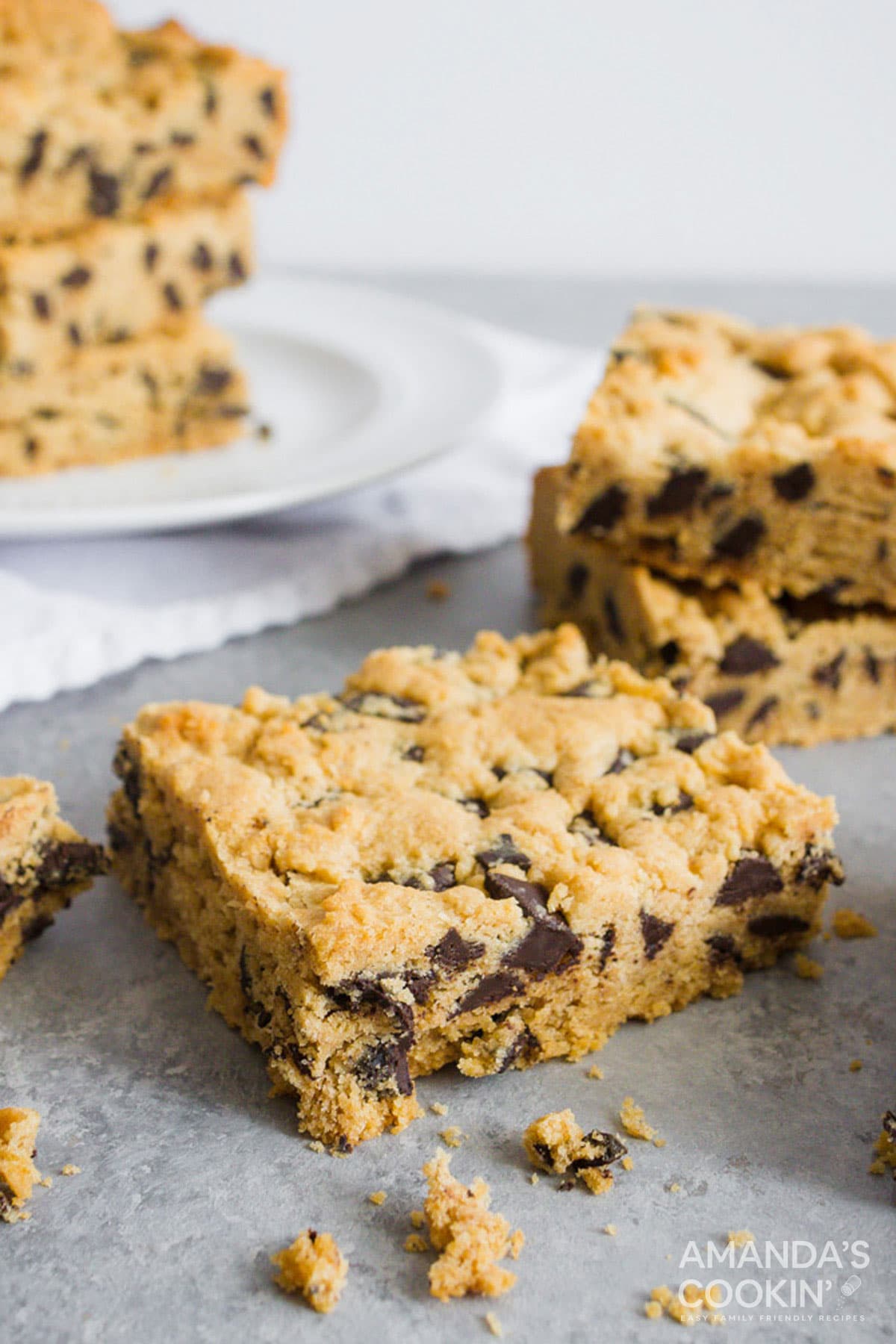 a chocolate chip cookie bar sitting on counter with more in background