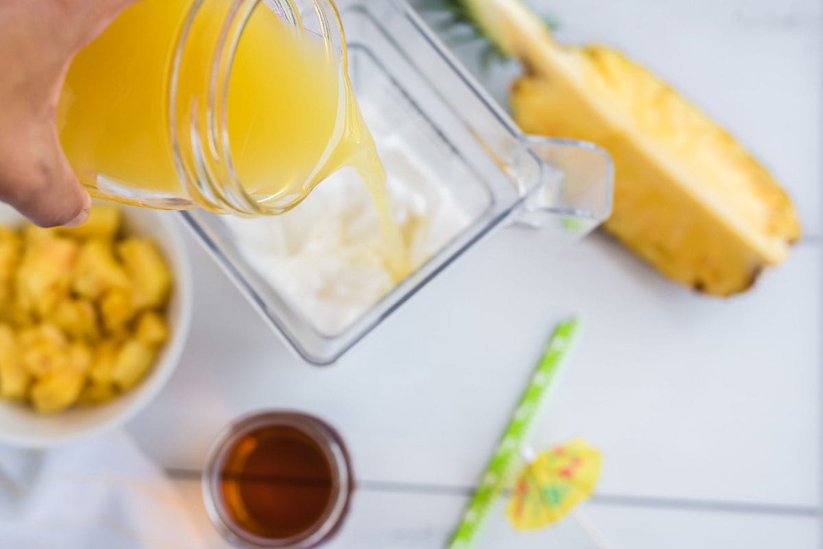 adding pineapple juice to blender